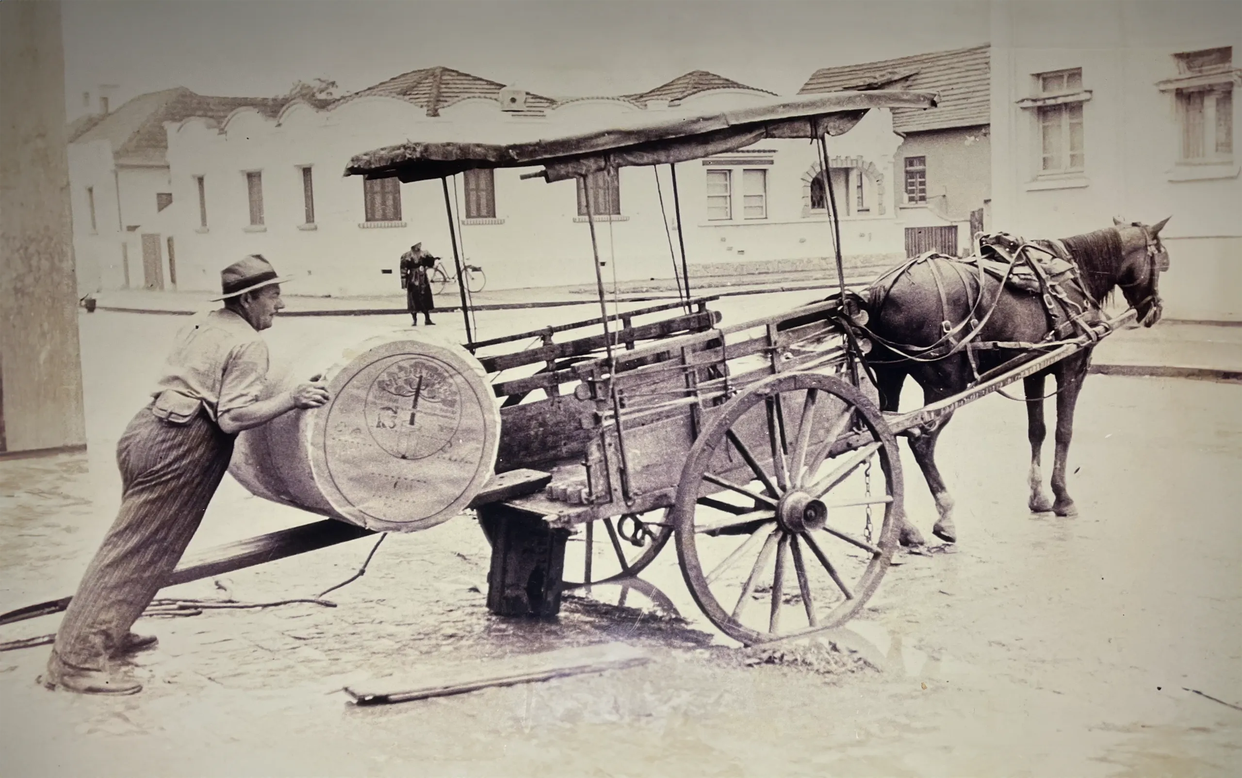 Black and white, historic picture of transporting barrels in a horse-drawn cart